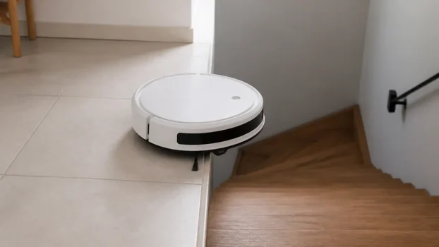 Aspirateur robot arrêté au bord d'une marche d'escalier